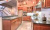 Customized chef’s kitchen with hardwood cabinetry, glass cabinet doors, and Silestone countertops.