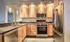 Contemporary kitchen with hardwood cabinetry, Silestone countertops, high-end fixtures and appliances, and stylish lighting.