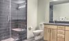 Master bath with glass shower enclosure and stylish plank tile.